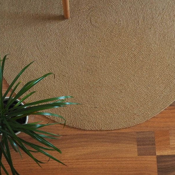 Green plant on a wooden surface with a textured brown mat